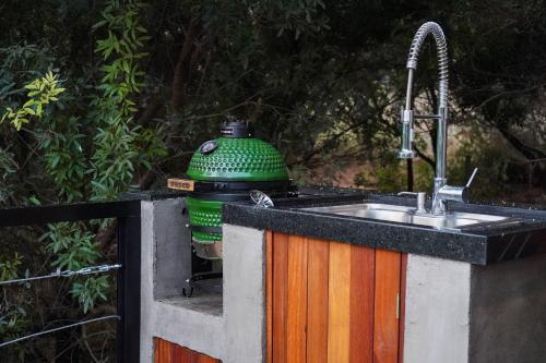 a kitchen sink with a green bottle on top of it at Casa Nengueta - Lapinha da Serra in Santana do Riacho