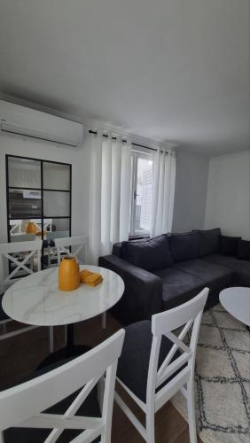 a living room with a couch and a table and chairs at Panonski raj in Palić