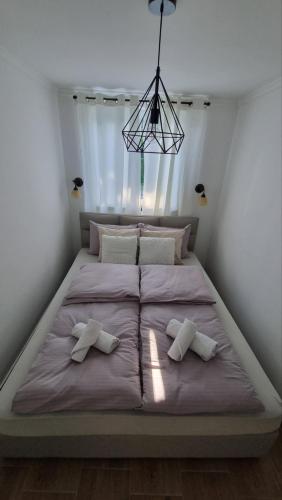 a large bed with two pillows on it in a bedroom at Panonski raj in Palić