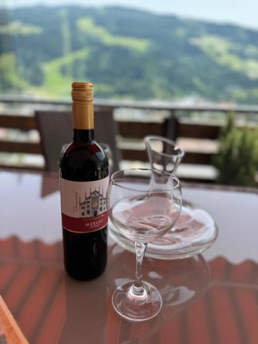 a bottle of wine and a wine glass on a table at Schnelli Appartement Schladming in Schladming