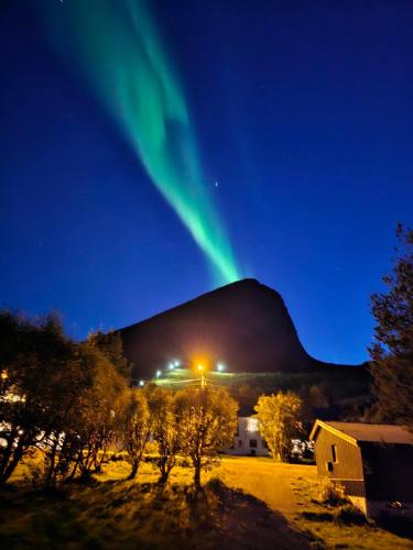 an image of the northern lights dancing over a mountain at Rigmorhuset in Fjordgård