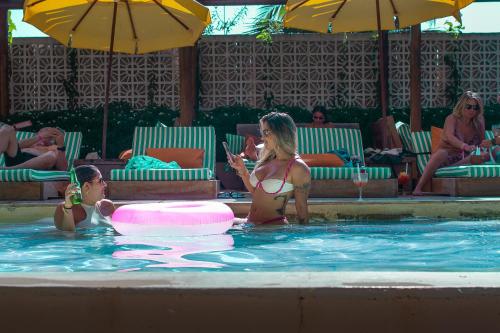 a woman in a swimming pool holding a glass of wine at Café Jeri Hotel - Adults Only in Jericoacoara