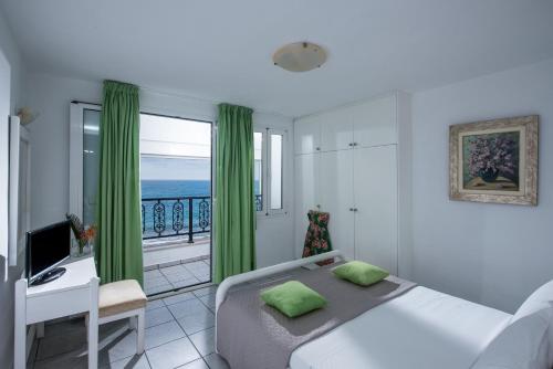 a bedroom with a bed and a balcony with the ocean at Villa Sonia in Hersonissos