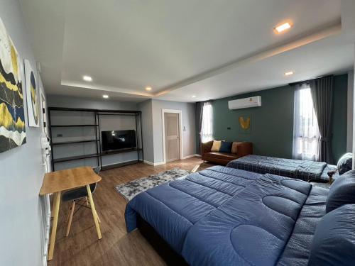 una camera con un grande letto blu e un divano di NAP IN NAN Poshtel a Ban Hua Wiang Nua