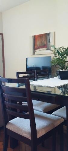 a glass dining room table with a chair and a desk at Quarto na Praia de Copacabana, excelente localização! in Rio de Janeiro