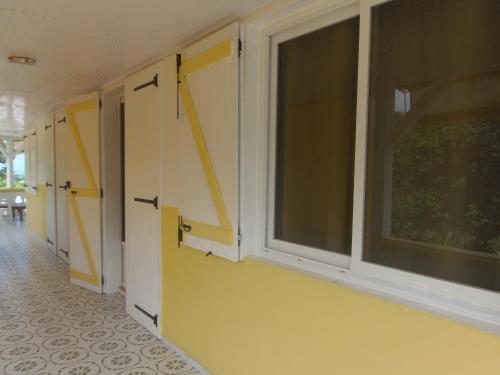 a hallway with yellow walls and a large window at Villa Mancina in Capesterre-Belle-Eau