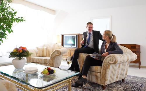 a man and a woman sitting on a chair in a living room at Hotel Mozart in Rorschach