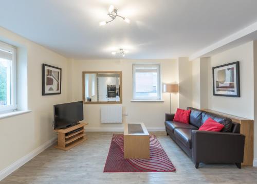 a living room with a couch and a tv at House of Fisher - Central Point in Basingstoke