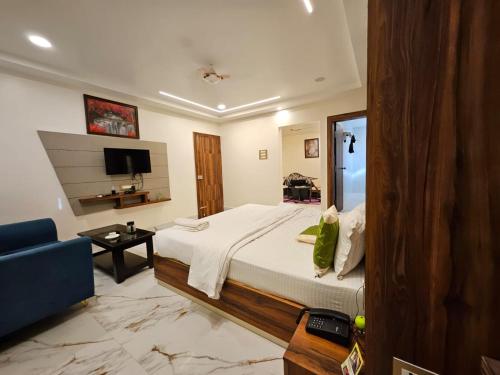 a bedroom with a large bed and a blue couch at HOTEL MAA LAXMI PALACE in Deoghar