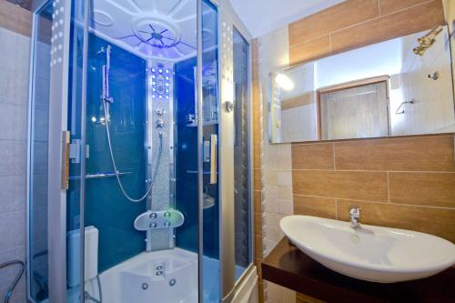 y baño con lavamanos, ducha y lavamanos. en Guesthouse Toitos, en Palaios Agios Athanasios