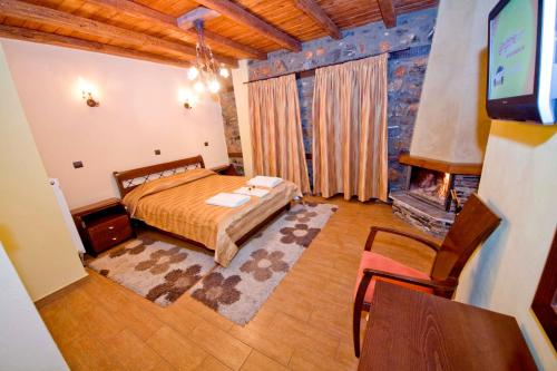 a bedroom with a bed and a fireplace at Guesthouse Toitos in Palaios Agios Athanasios