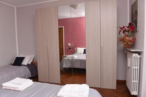 a room with two beds and a mirror at Casa Dante in Romano di Lombardia