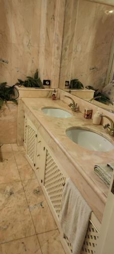 a marble bathroom with two sinks and towels at B&B Villa Victoria in Ragusa