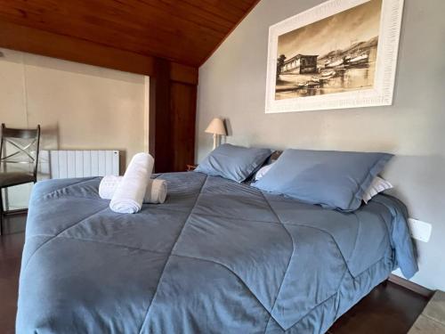 a bedroom with a large blue bed with blue pillows at Pousada Canela Garden in Canela