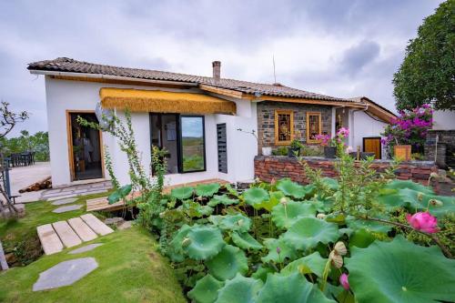 a small house with a garden in front of it at 张家界东篱山居民宿- Free pick up service in Zhangjiajie