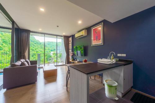 a kitchen with a sink and a living room at The Valley at Sunshine, Panoramic in Pak Chong