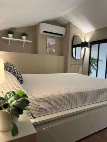 une chambre avec un lit blanc dans une pièce dans l'établissement T2 parking privé, centre, plage et gare, à Les Playes