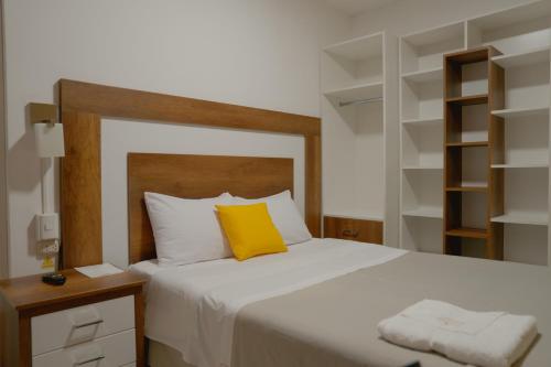 a bedroom with a bed with a yellow pillow on it at Hotel San Martín in San Juan de Marcona