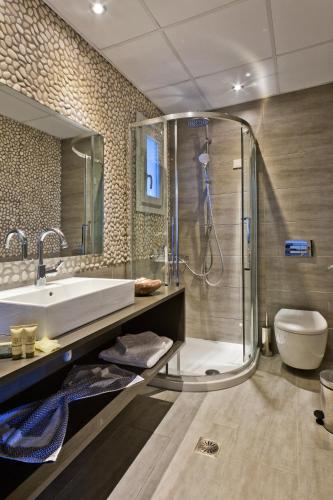 a bathroom with a tub and a shower and a toilet at Alsalos villas in Amoopi