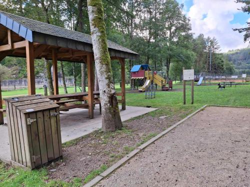 a park with a picnic shelter and a tree at Label Semois Gite rural 3 épis in Bouillon