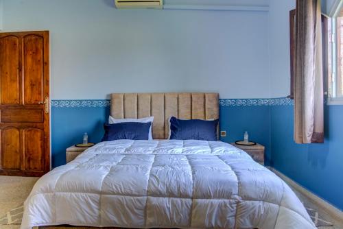 a blue bedroom with a large bed with blue walls at Dar Abaraz in Taroudant