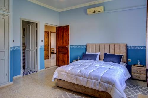 a bedroom with a large bed with blue walls at Dar Abaraz in Taroudant