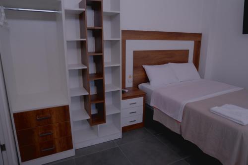 a small bedroom with a bed and a book shelf at Hotel San Martín in San Juan de Marcona