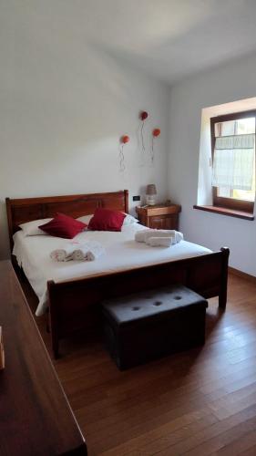 a bedroom with a large bed with white sheets and red pillows at La Casetta sotto la Torre in Lubriano