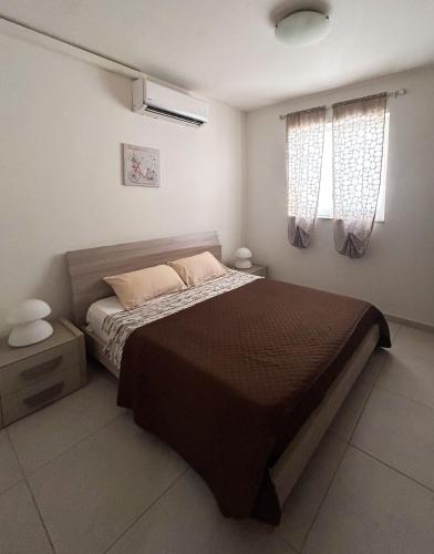 una camera con un grande letto e due finestre di St Pauls Bay 2 bedrooms a San Pawl il-Baħar