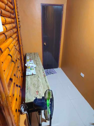 a room with a bed and a table with a fan at Casa Celine Dumaguete in Dumaguete