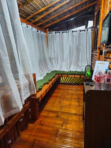 a room with a bed with white curtains at Casa Celine Dumaguete in Dumaguete