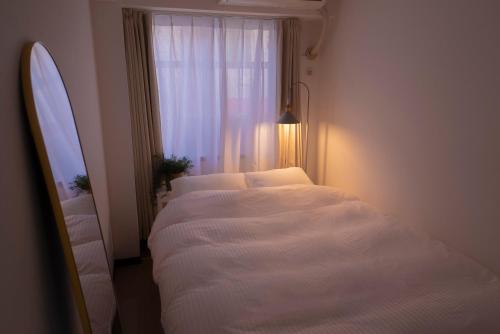a bedroom with two beds and a window at 花宿新宿 HANAYADO SHINJUKU in Tokyo