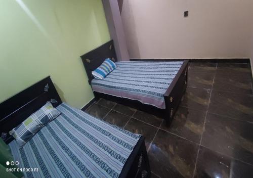 two twin beds in a room with at Al Qadir Residence in Multan