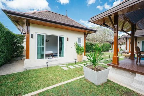 a house with a porch and a patio at Tranquil 3 Bedroom Garden Pool Villa in Laguna Phuket