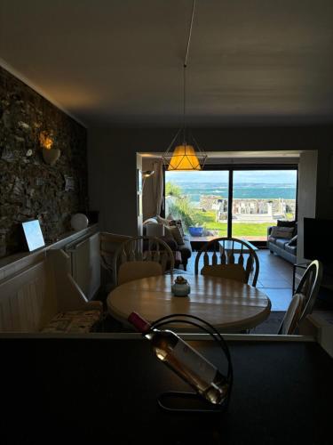 a kitchen with a table and chairs and a view of a room at Splash Cottage beach house with Sea lapping Garden in Bangor