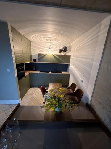 a room with a table with a vase of flowers on it at WieloApartment Radom - Paderewskiego in Radom