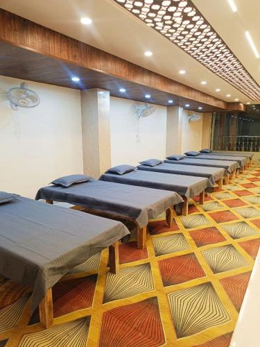 a row of beds lined up in a room at The Royal Sahdeo Venue in Gaya