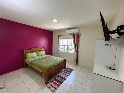 a bedroom with a bed and a purple wall at Cozy one bedroom apartment in Lambeau