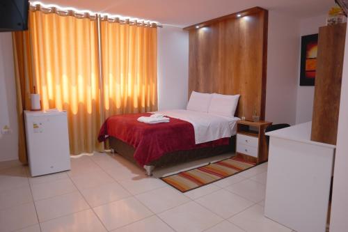 a bedroom with a bed with a red blanket at Hotel San Martín in San Juan de Marcona