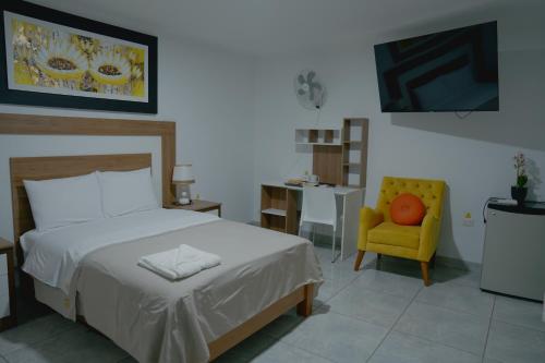 a bedroom with a bed and a yellow chair at Hotel San Martín in San Juan de Marcona