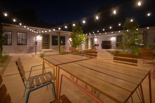 a patio with wooden tables and chairs and lights at Talbot Commons Hotel in Taylor