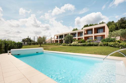 une maison avec piscine devant un immeuble dans l'établissement Le Mas des Oliviers, à Gréoux-les-Bains