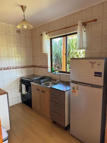 a kitchen with a refrigerator and a sink at Cabañas Anavai Rapa Nui in Hanga Roa