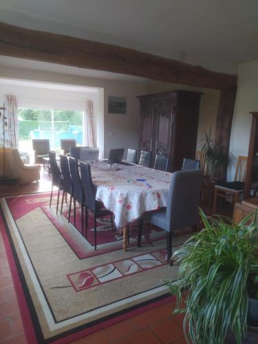 une salle à manger avec une table et des chaises dans l'établissement maison Normandie 20 personnes, à Thibouville