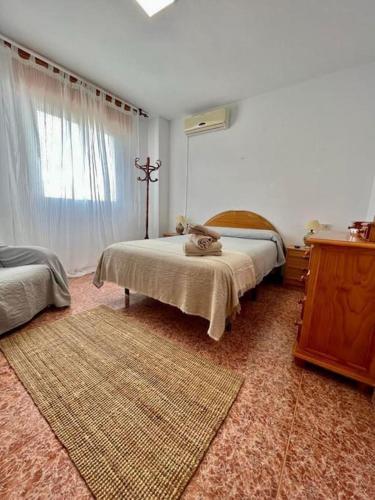 a bedroom with two beds and a window and a rug at Casa las 3 lunas in San José