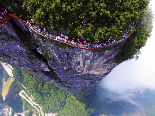 a group of people on a bridge on a mountain at 张家界东篱山居民宿- Free pick up service in Zhangjiajie
