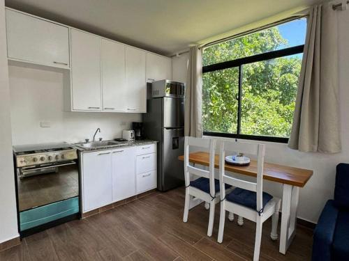 a kitchen with white cabinets and a table and a sink at Flat Sea & Sun Monte Vista in Sosúa