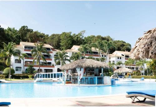a swimming pool with a resort in the background at Flat Sea & Sun Monte Vista in Sosúa