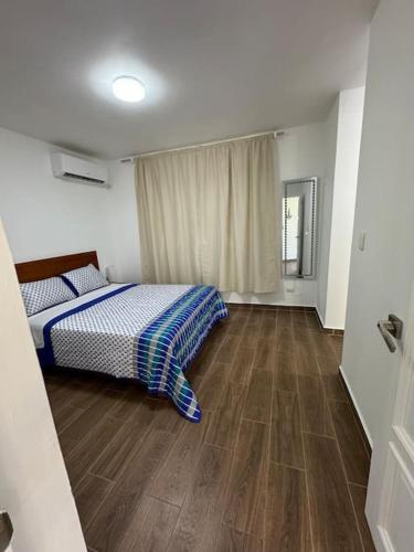 a bedroom with a bed and a wooden floor at Flat Sea & Sun Monte Vista in Sosúa