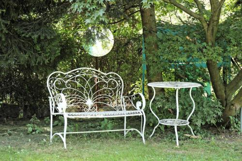 a wrought iron bench and a table in a garden at TUTTO House&Home in Lubno